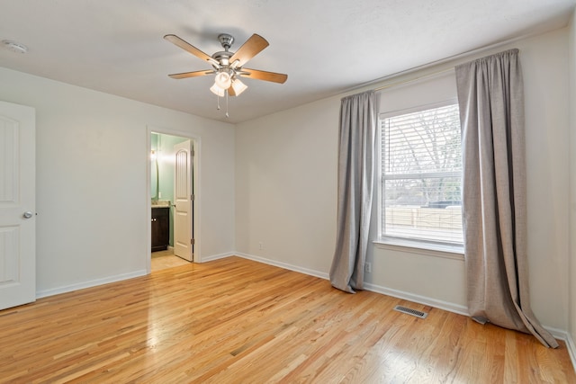 interior space with ensuite bath, ceiling fan, and light hardwood / wood-style flooring