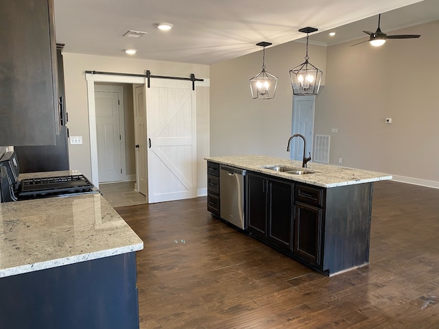 kitchen with pendant lighting, a center island with sink, a barn door, dark hardwood / wood-style flooring, and stainless steel appliances