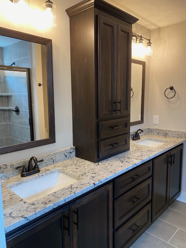 bathroom with tile patterned flooring, vanity, and a shower with door