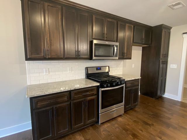 kitchen featuring backsplash, dark hardwood / wood-style flooring, dark brown cabinets, and appliances with stainless steel finishes