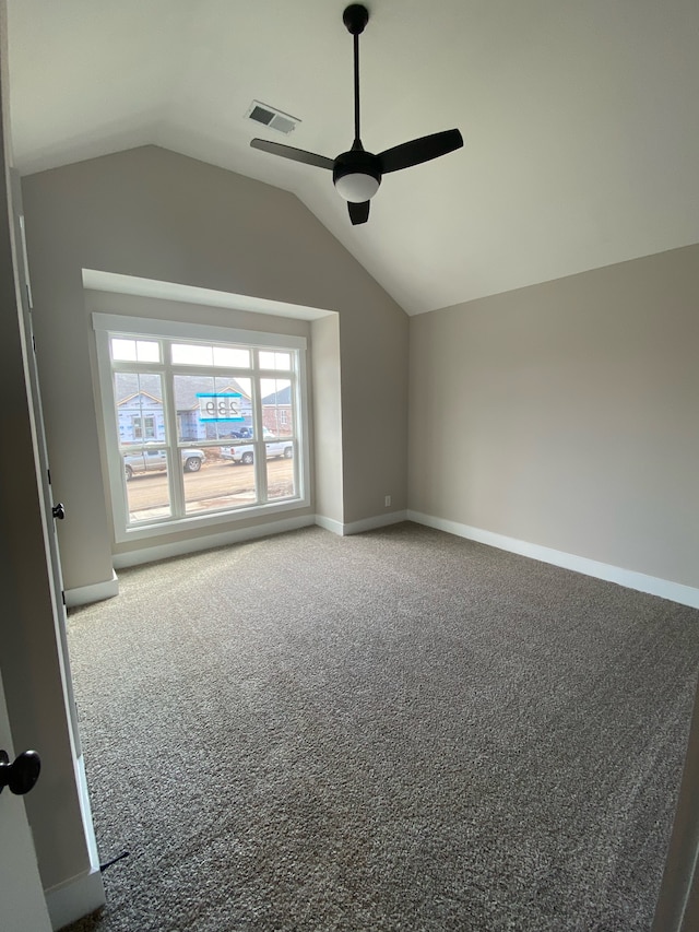 carpeted spare room featuring ceiling fan and vaulted ceiling