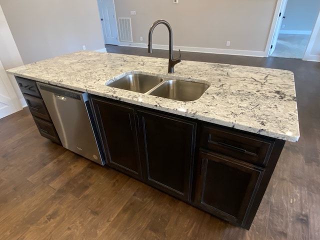 kitchen featuring stainless steel dishwasher, light stone counters, sink, and dark wood-type flooring