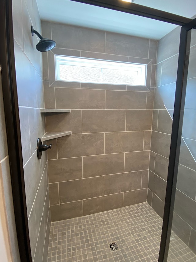 bathroom featuring tiled shower and a wealth of natural light