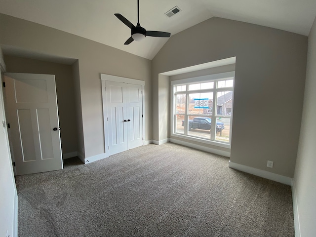 unfurnished bedroom featuring carpet floors, a closet, ceiling fan, and lofted ceiling