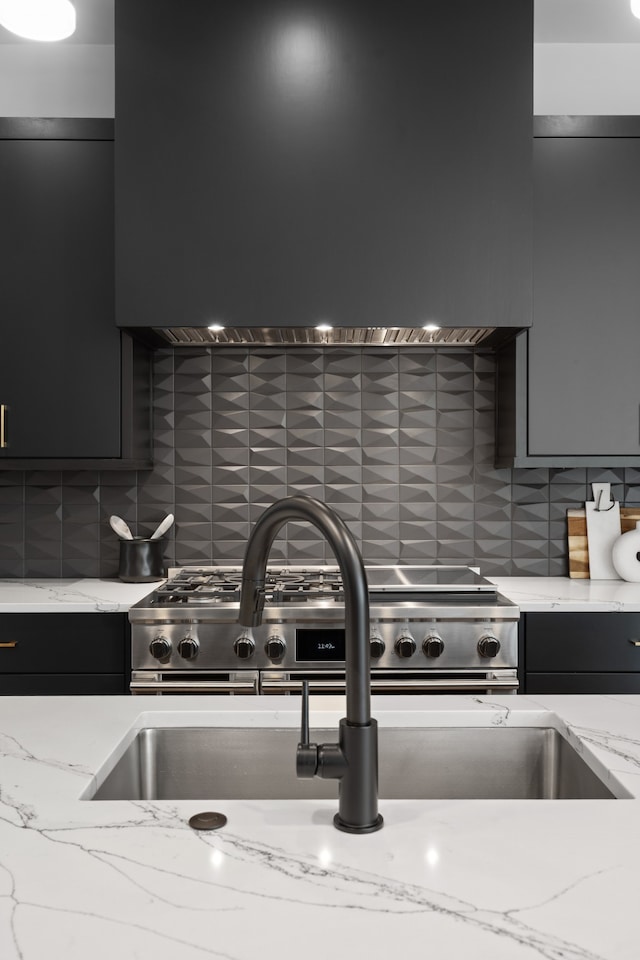 kitchen with tasteful backsplash, light stone countertops, and wall chimney exhaust hood