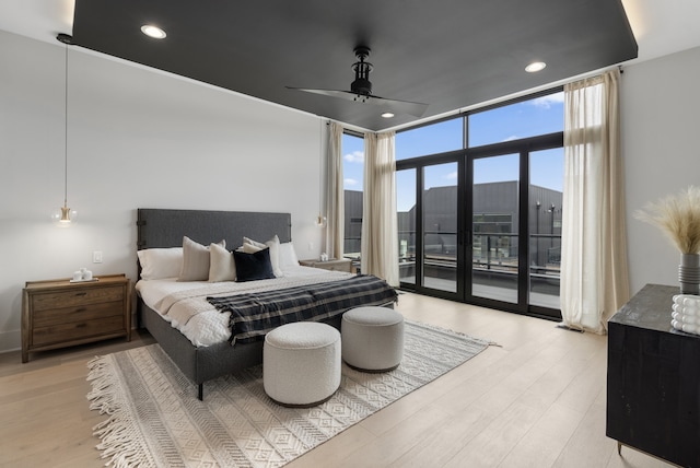 bedroom with multiple windows, ceiling fan, light hardwood / wood-style flooring, and access to exterior