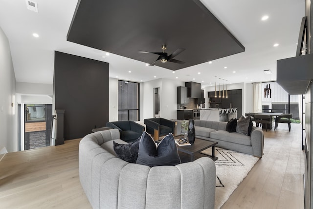 living room with light hardwood / wood-style flooring and ceiling fan