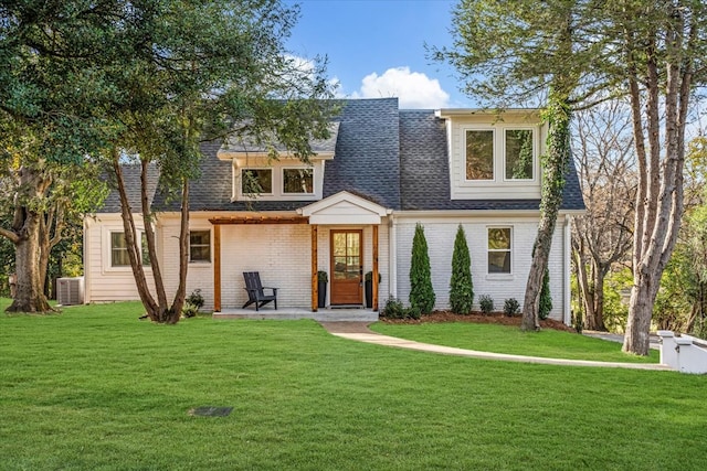 view of front of property with a front lawn and central air condition unit