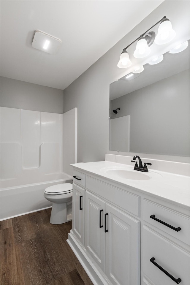 full bathroom with vanity, toilet, wood-type flooring, and bathing tub / shower combination