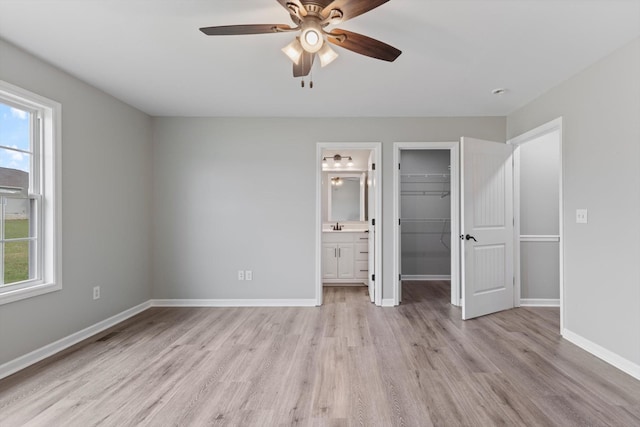 unfurnished bedroom with ensuite bath, ceiling fan, sink, and light hardwood / wood-style floors