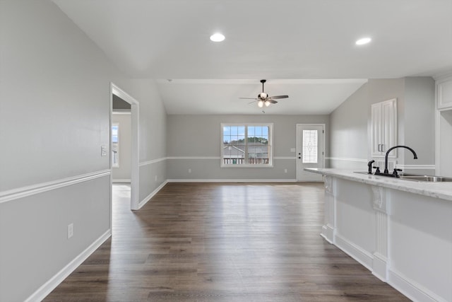 interior space featuring ceiling fan, sink, lofted ceiling, and dark wood-type flooring