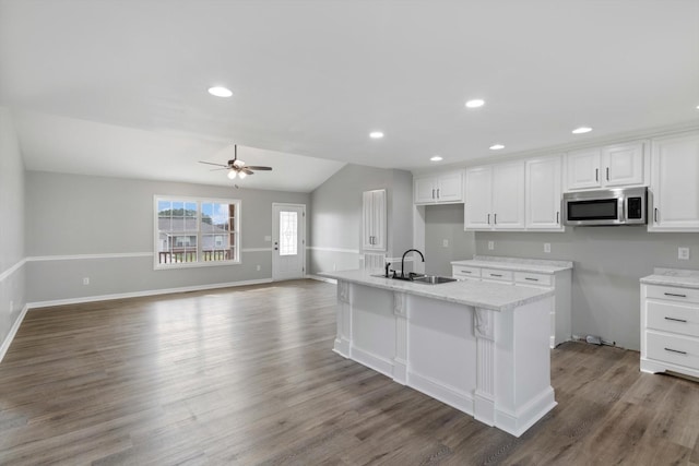 kitchen with dark hardwood / wood-style flooring, ceiling fan, sink, white cabinetry, and lofted ceiling