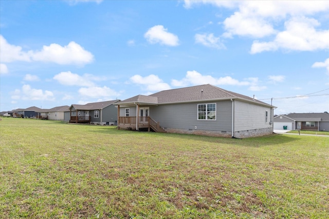 rear view of house with a deck and a yard