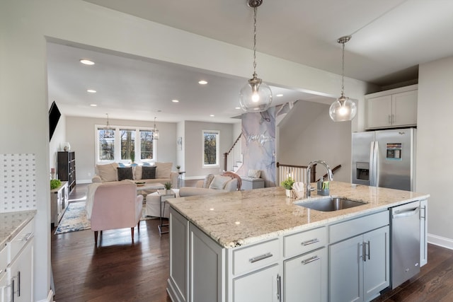 kitchen featuring a kitchen island with sink, white cabinets, sink, dark hardwood / wood-style floors, and appliances with stainless steel finishes