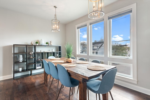 dining space with wood-type flooring and an inviting chandelier