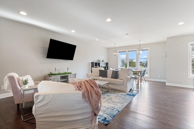 living room with dark wood-type flooring and a notable chandelier