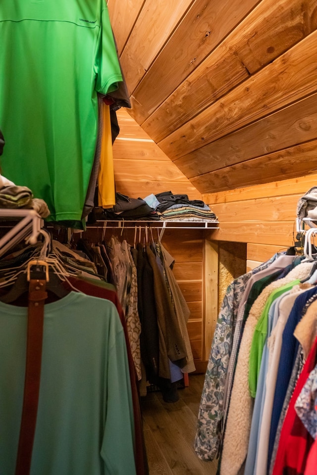 walk in closet featuring wood-type flooring and vaulted ceiling