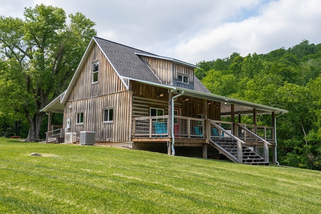 back of house with central AC and a yard