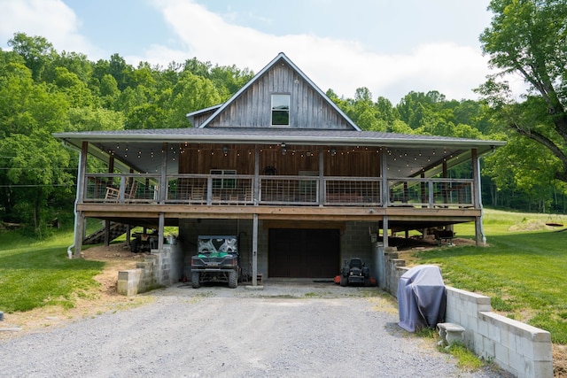 country-style home featuring a front lawn, a deck, and a garage