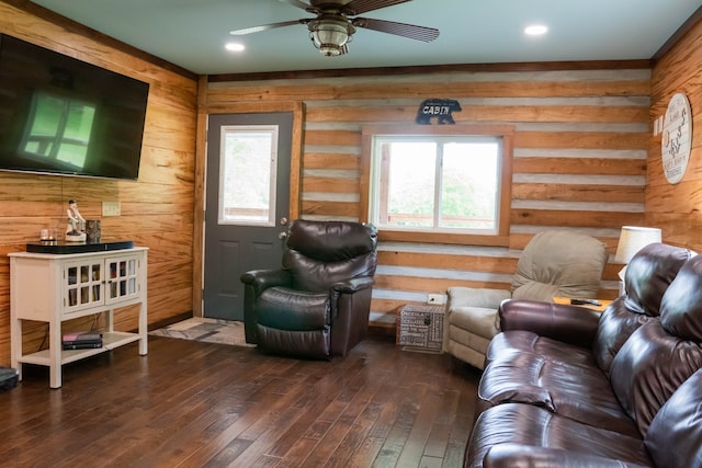 living room featuring log walls, hardwood / wood-style flooring, plenty of natural light, and ceiling fan