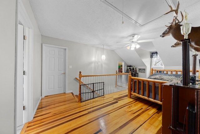 bedroom featuring hardwood / wood-style floors, a textured ceiling, and lofted ceiling