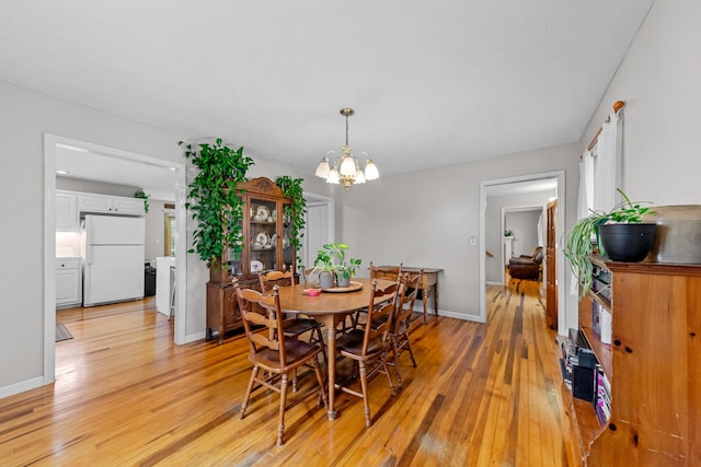 dining room with a notable chandelier and light hardwood / wood-style floors