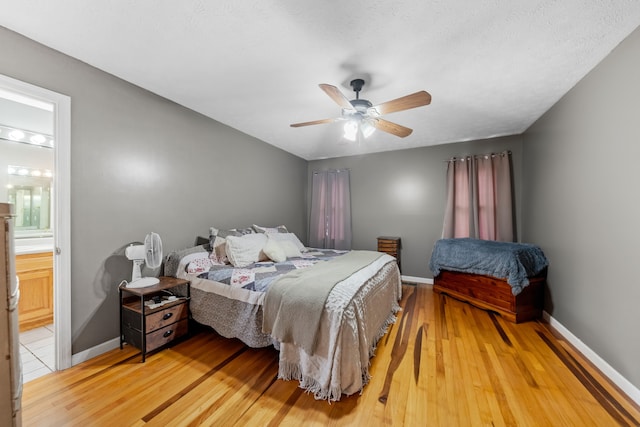 bedroom featuring hardwood / wood-style flooring, ensuite bathroom, and ceiling fan