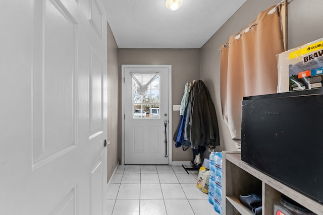 entryway featuring light tile patterned floors and a textured ceiling