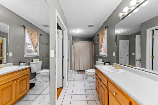 bathroom featuring vanity, tile patterned floors, a textured ceiling, and toilet