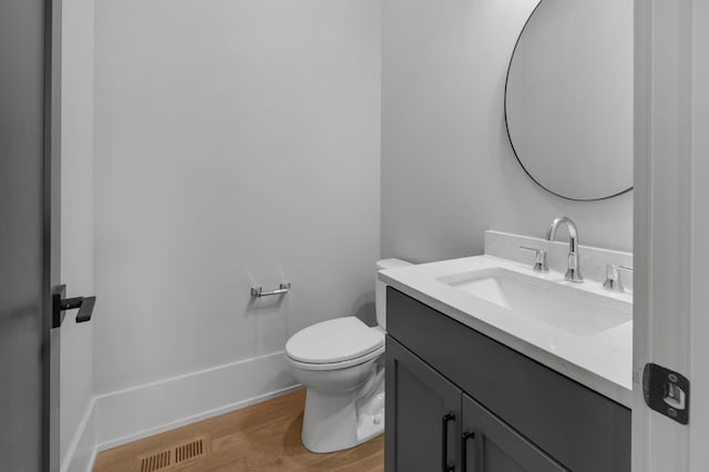 bathroom with hardwood / wood-style floors, vanity, and toilet