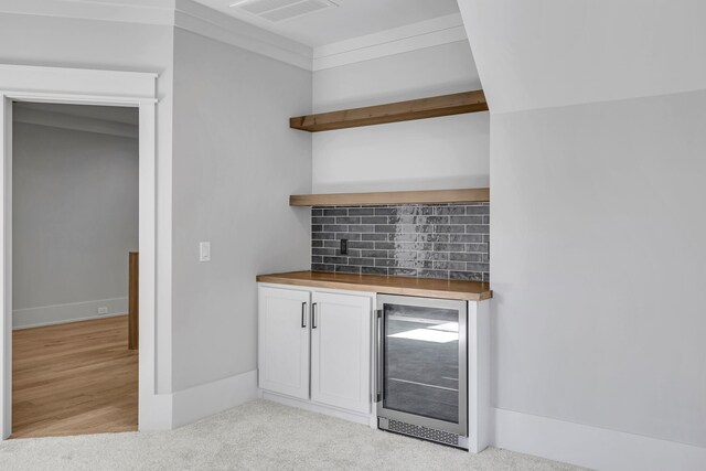 bar featuring backsplash, light wood-type flooring, butcher block countertops, white cabinetry, and beverage cooler