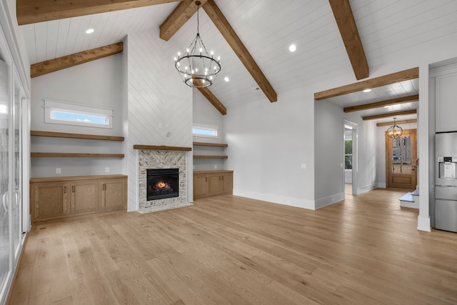 unfurnished living room with a stone fireplace, beamed ceiling, high vaulted ceiling, a notable chandelier, and light hardwood / wood-style floors