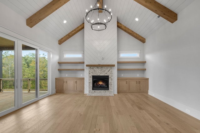 unfurnished living room with a fireplace, light hardwood / wood-style floors, high vaulted ceiling, and a chandelier