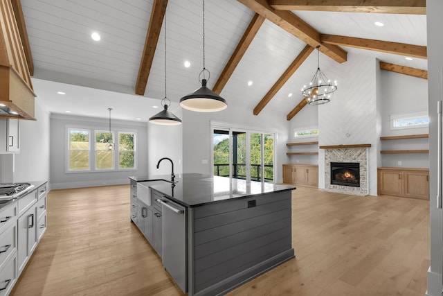 kitchen featuring pendant lighting, white cabinetry, a center island with sink, and light hardwood / wood-style floors