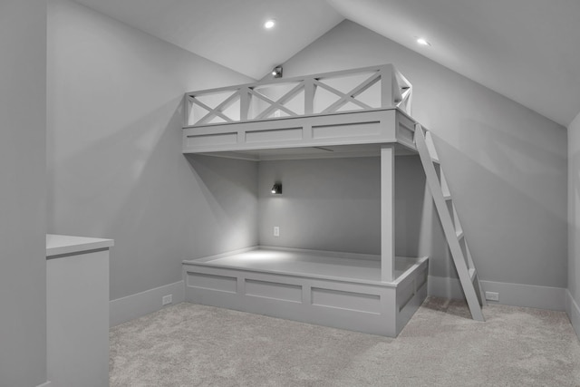 unfurnished bedroom featuring light colored carpet and vaulted ceiling