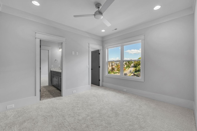 unfurnished bedroom featuring carpet flooring, ensuite bath, ceiling fan, and ornamental molding