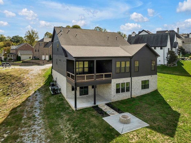 rear view of property with a sunroom, a yard, and a patio