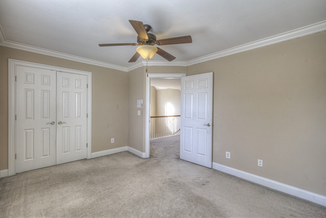 unfurnished bedroom with a closet, light colored carpet, ceiling fan, and ornamental molding