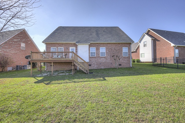 rear view of property featuring a deck, central AC unit, and a lawn