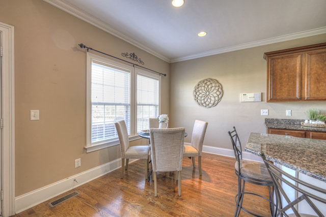 dining room with crown molding and dark hardwood / wood-style flooring