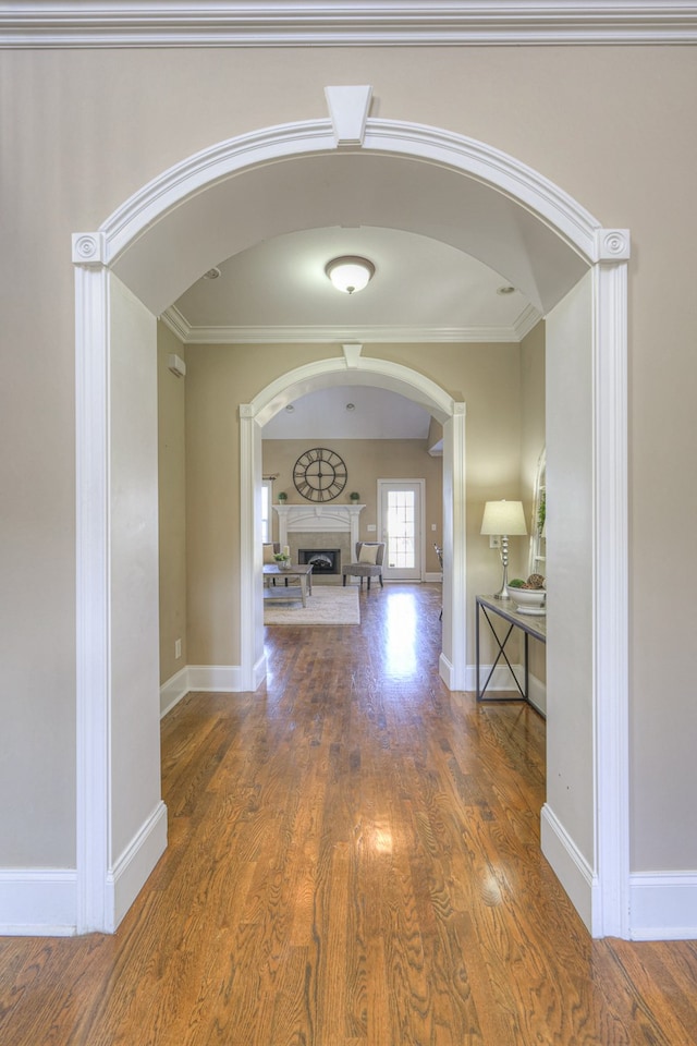 corridor with dark hardwood / wood-style flooring and crown molding