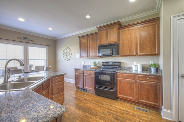 kitchen featuring sink, dark hardwood / wood-style floors, crown molding, and black appliances