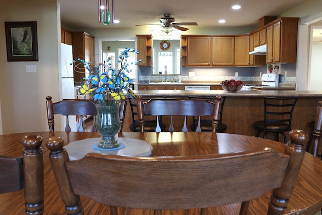 kitchen featuring sink, white appliances, hanging light fixtures, and ceiling fan