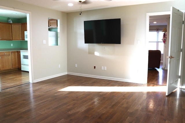 unfurnished living room with dark wood-type flooring and ceiling fan