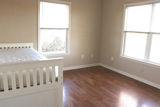 unfurnished bedroom with dark hardwood / wood-style floors