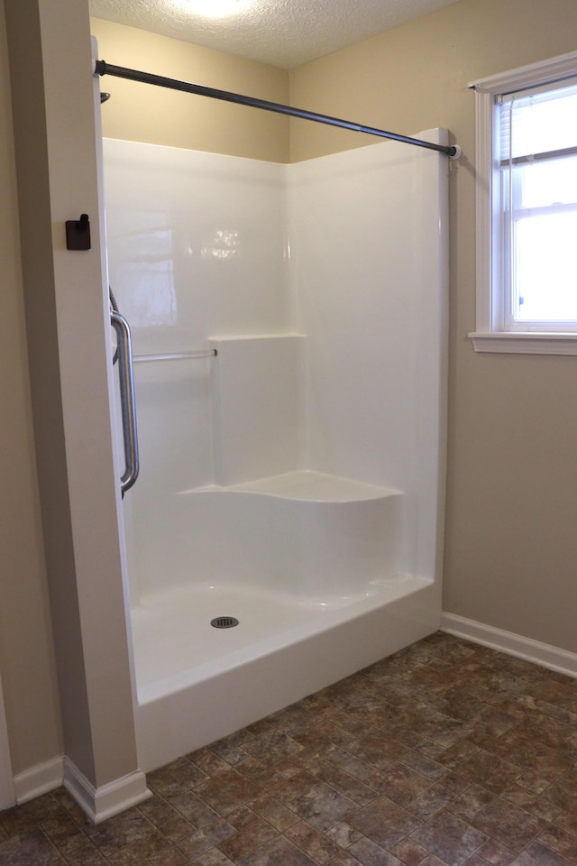 bathroom featuring a textured ceiling and a shower