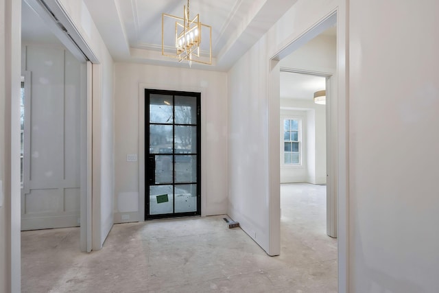 entrance foyer featuring a tray ceiling and a chandelier