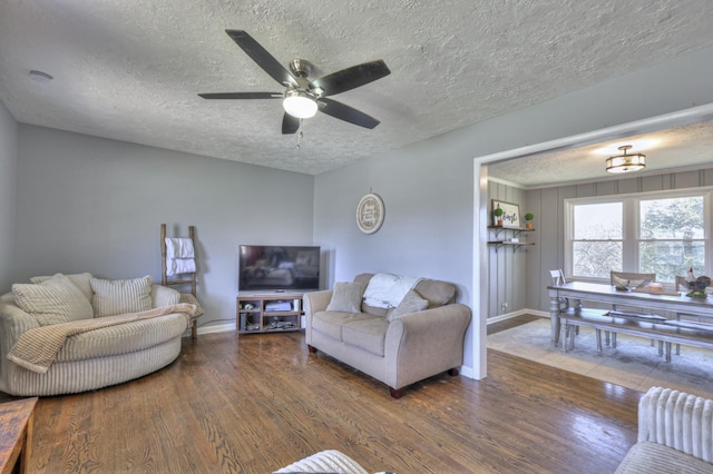 living room featuring a textured ceiling, dark hardwood / wood-style floors, and ceiling fan