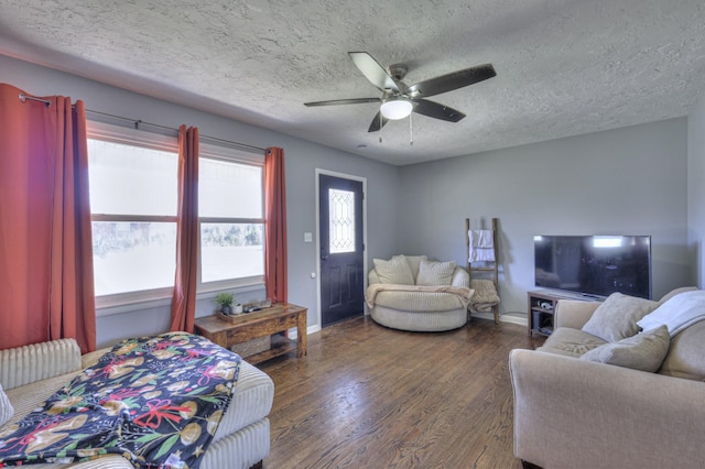 living room with ceiling fan, dark wood-type flooring, and a textured ceiling