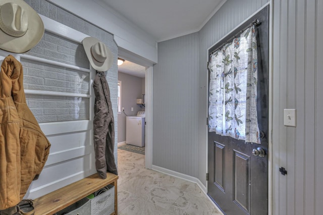 foyer featuring washer and dryer, wood walls, and ornamental molding